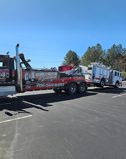 Tow truck hauling fire engine